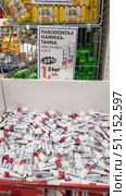 A photo from a supermarket shelf, where Parodontax toothpaste is presented in small 20 ml tubes. The tubes are laid out in a large box, above which there is an advertising poster with information about a -33% discount and the price for the package. Other products are visible in the background: laundry soap, food and customers. The image conveys the atmosphere of the sales area, focusing on the promotion and affordable price of the popular brand of toothpaste. (2019 год). Редакционное фото, фотограф Анна Кривицкая / Фотобанк Лори