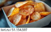 Crunchy Potato Chips Served in a White Box on a Rustic Wooden Table During a Snack Time Gathering. Стоковое AI-изображение, AI-художник Юлия Гапеенко / Фотобанк Лори