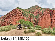 Senior tourist sitting on wooden bench at Jety Oguz Gorge viewpoint, Kyrgyzstan. Стоковое фото, фотограф Ирина Кононова / Фотобанк Лори