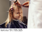 Little Girl Gets Her Bangs Trimmed at the Hairdresser's Studio. Стоковое фото, фотограф Aleksandr Golubev / Фотобанк Лори