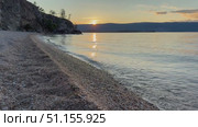 Video of Baikal Lake on summer sunset. View of pebble beach of Olkhon Island on quiet August evening. Picturesque seascape. Natural background. Summer travel and outdoor recreation. Стоковое видео, видеограф Виктория Катьянова / Фотобанк Лори
