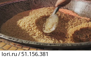 The chef stirs steaming rice in a large pilaf cauldron with a slotted spoon. Стоковое видео, видеограф Aleksey Kidisyuk / Фотобанк Лори