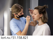 Beauty Transformation Takes Place in a Cozy Salon as a Woman is Pampered by a Skilled Make-Up Artist. Стоковое фото, фотограф Aleksandr Golubev / Фотобанк Лори