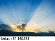 Majestic sunset over mountains with dramatic rays of light illuminating the sky. Стоковое фото, фотограф Наталья Семкина / Фотобанк Лори