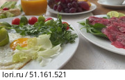 Setting of breakfast includes coffee, fresh orange juice, eggs on table in hotel restaurant Breakfast with coffee surrounded by various food Breakfast Buffet Concept, Breakfast Time in Luxury Hotel. Стоковое видео, видеограф Zita Khasanova / Фотобанк Лори