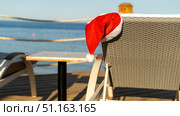Santaclaus or Santa Claus hat on a sun lounger by the sea. Стоковое фото, фотограф Igor Skripachev / Фотобанк Лори
