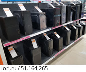 Electronics store display cases with personal computer cases. The shelves feature mini/micro ATX and ATX models without power supplies. The cases vary in design, size and functionality — from simple office solutions to modern gaming cases with decorative elements. Each product is provided with an information price tag with characteristics and cost. The display case is neatly decorated, which emphasizes the range and convenience of choosing components for assembling a computer. (2019 год). Редакционное фото, фотограф Анна Кривицкая / Фотобанк Лори