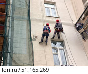 Промышленные альпинисты выполняют штукатурные работы. Редакционное фото, фотограф Мария Сергеева / Фотобанк Лори