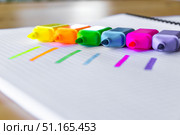Bright multicolored highlighter pens placed in a creative row on squared paper, with bold fluorescent marker strokes showing each color. The vivid neon tones create a vibrant and playful layout, ideal for educational content, school advertising, creative workspaces and office organization concepts. Стоковое фото, фотограф Анастасия Мерчик / Фотобанк Лори