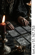 Fortune teller interpreting tarot cards on black velvet, soft candlelight casting mystical shadows across divination scene. Стоковое AI-изображение, AI-художник Юрий Поздников / Фотобанк Лори