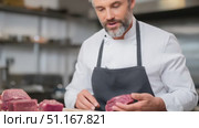 Experienced chef comparing various red meat cuts, carefully evaluating quality and texture inside professional kitchen workspace, ensuring optimal ingredient selection for cooking. Стоковое AI-видео, аниматор Юрий Поздников / Фотобанк Лори