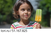 Happy child licking vibrant two colored ice pop, smiling brightly during sunny day, embodying carefree summer moments. Стоковое AI-видео, аниматор Юрий Поздников / Фотобанк Лори