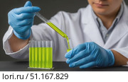 Laboratory technician pouring green fluorescent liquid from a pipette into a test tube, performing scientific research in a modern laboratory. Стоковое AI-видео, аниматор Юрий Поздников / Фотобанк Лори