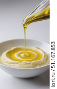 Golden extra virgin olive oil drizzling over creamy hummus, creating circular patterns inside white ceramic bowl with minimalist studio lighting. Стоковое AI-видео, аниматор Юрий Поздников / Фотобанк Лори