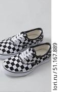 Checkered shoes spinning on white background, displaying geometric black and white pattern with modern design elegance. Стоковое AI-видео, аниматор Юрий Поздников / Фотобанк Лори