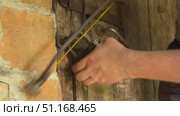 Man cutting padlock with hacksaw. Vintage wooden door in brick wall. Стоковое видео, видеограф Vadzim Yakubovich / Фотобанк Лори