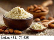 Almond flour. Almond nuts and almond flour in a wooden bowl and spoon. White table background. Grated almonds pile. Gluten-free produce for health. Low Carb Keto, celiac, paleo, and wheat-free diets. Стоковое AI-изображение, AI-художник Марина Демидюк / Фотобанк Лори