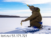 Fishman ice fishing on frozen lake at sunny winter day. Стоковое фото, фотограф Сергей Чуйко / Фотобанк Лори