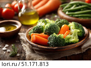 Large bowl of freshly steamed mixed fresh vegetables. Vibrant dish of Steaming Vegetables on old wooden table. Broccoli, carrots, green beans, and snow peas. Healthy cooking. Vegetable garden produce. Стоковое AI-изображение, AI-художник Марина Демидюк / Фотобанк Лори