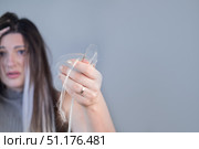 Young woman showing effects of severe hair loss after brushing strands in beauty or hair care context. Стоковое фото, фотограф Svetlana Golovco / Фотобанк Лори