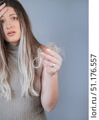 Upset young woman noticing hair loss on hairbrush showing early signs of alopecia and weak brittle hair. Стоковое фото, фотограф Svetlana Golovco / Фотобанк Лори
