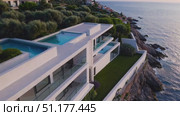 Smooth slow-motion aerial glides over layered terraces and a rooftop pool of a sleek seaside residence — elegant 4K 16:9 architecture clip for property promos. Стоковое AI-видео, аниматор Владислав Войтов / Фотобанк Лори