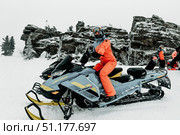 Sheregesh, Russia, 4 January 2021, Snowboarders skiers sit on snowmobile. Редакционное фото, фотограф Spirit River / Фотобанк Лори