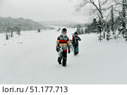 Sheregesh, Russia, 4 January 2021, Snowboarder skier walk and hold snowboard. Редакционное фото, фотограф Spirit River / Фотобанк Лори