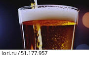 Medium close-up of a straight-sided pint filled with light-amber lager; dense white foam against a cool blue/black background. 4K MP4, no people. Стоковое AI-видео, аниматор Владислав Войтов / Фотобанк Лори