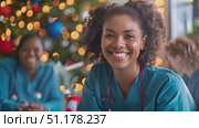 Healthcare professionals gather joyfully for a holiday celebration, showcasing camaraderie and festive spirit in a decorated setting. Стоковое AI-видео, аниматор Данила Большаков / Фотобанк Лори