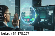 A business professional reviews critical data visualizations on a large monitor in a modern office as the sun sets over the city skyline. Стоковое AI-видео, аниматор Данила Большаков / Фотобанк Лори