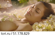 A woman enjoys a rejuvenating spa treatment surrounded by delicate flowers and calming waters, providing a sense of relaxation. Стоковое AI-видео, аниматор Данила Большаков / Фотобанк Лори