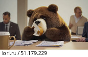 A bear sits at a conference table, looking exhausted while coworkers engage in a lively discussion amidst paperwork. Стоковое AI-видео, аниматор Данила Большаков / Фотобанк Лори