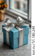Gift Box Wrapped in Blue Paper With Silver Ribbon Sits on a Table by the Window. Стоковое AI-изображение, AI-художник Юлия Гапеенко / Фотобанк Лори