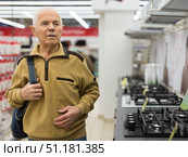 elderly man choosing gas stove in showroom of electrical appliance store. Стоковое фото, фотограф Татьяна Яцевич / Фотобанк Лори
