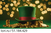 Green top hat is perched on top of large pile of coins, creating striking image of wealth and prosperity. Shiny coins contrast with vibrant color of hat, making for intriguing visual display. Стоковое AI-видео, аниматор Данила Большаков / Фотобанк Лори