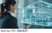 An expert discusses architectural concepts with a holographic model of a modern building in a sleek office environment. Стоковое AI-видео, аниматор Данила Большаков / Фотобанк Лори