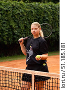 Teenage Girl Showcases Determination While Training on a Vibrant Outdoor Tennis Court. Стоковое фото, фотограф Aleksandr Golubev / Фотобанк Лори