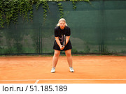 Teenage Girl Perfecting Her Serve on an Outdoor Tennis Court During Afternoon Practice. Стоковое фото, фотограф Aleksandr Golubev / Фотобанк Лори