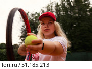 Training Hard at the Tennis Court, a Teenage Girl Prepares to Serve Under the Clear Blue Sky. Стоковое фото, фотограф Aleksandr Golubev / Фотобанк Лори