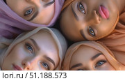 A group of four women with headscarves come together, celebrating their individuality and diversity in a picturesque outdoor setting. Стоковое AI-видео, аниматор Данила Большаков / Фотобанк Лори