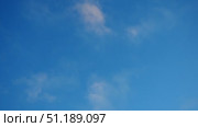 A tranquil blue sky adorned with soft, fluffy clouds creates a serene atmosphere. The gentle movement of the clouds invites viewers to pause and appreciate nature beauty on this lovely day. Стоковое видео, видеограф Юлия Петровская / Фотобанк Лори