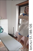 Woman wearing blue dress putting on white shirt. Стоковое видео, видеограф Константин Шишкин / Фотобанк Лори