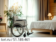 Elegant Wheelchair in a Serene Bedroom Setting with Soft Natural Light, Sheltered by Beautiful Greenery and Modern Decor, Providing Comfort and Accessibility. Стоковое AI-изображение, AI-художник Башкирова Анна / Фотобанк Лори