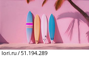 Three surfboards of various colors and designs are neatly lined up against soft pink wall. The surfboards stand out against pastel background, creating visually striking image. Стоковое AI-видео, аниматор Данила Большаков / Фотобанк Лори