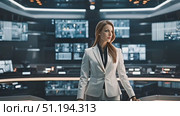 Professional woman in a sharp white suit stands assertively within a modern command center, surrounded by advanced technological workstations and digital displays. Стоковое AI-видео, аниматор Данила Большаков / Фотобанк Лори
