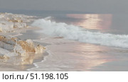 Waves gently crash on a serene shoreline at sunset in a peaceful coastal location. Стоковое AI-видео, аниматор Ekaterina Ismagilova / Фотобанк Лори