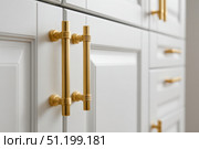Close-up macro of golden cabinet hardware on white doors. Handle with brass finish. Minimalist simple interior style. Cabinet door double doors with both handles. Furniture base set design. Стоковое AI-изображение, AI-художник Марина Демидюк / Фотобанк Лори