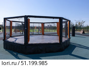 Magnitogorsk, Russian Federation - August 24, 2025: Urban resort attraction featuring a modern octagonal training cage with vibrant orange accents in a sunny outdoor sports facility. Редакционное фото, фотограф Ирина Ручушкина / Фотобанк Лори