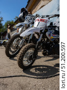 Magnitogorsk, Russian Federation - August 23, 2025: Enduro motorcycles lined up in a sunny outdoor setting, showcasing detailed tires and vibrant designs, perfect for racing enthusiasts and sports photography. Редакционное фото, фотограф Ирина Ручушкина / Фотобанк Лори
